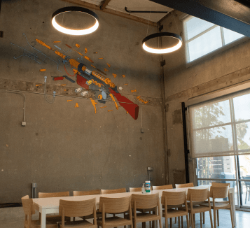 A sleek wooden conference table facing a colorful mural on a concrete wall